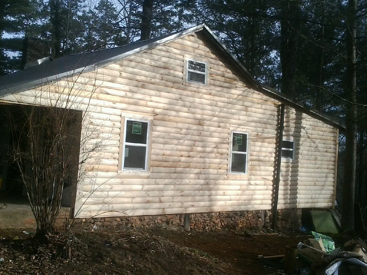 New log siding and dark metal roofing on a gable end in Blauvelt