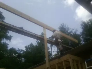 Carpenter setting a ridge beam over a new addition frame — Ice Dam Removal by Roofing Brothers in Blauvelt