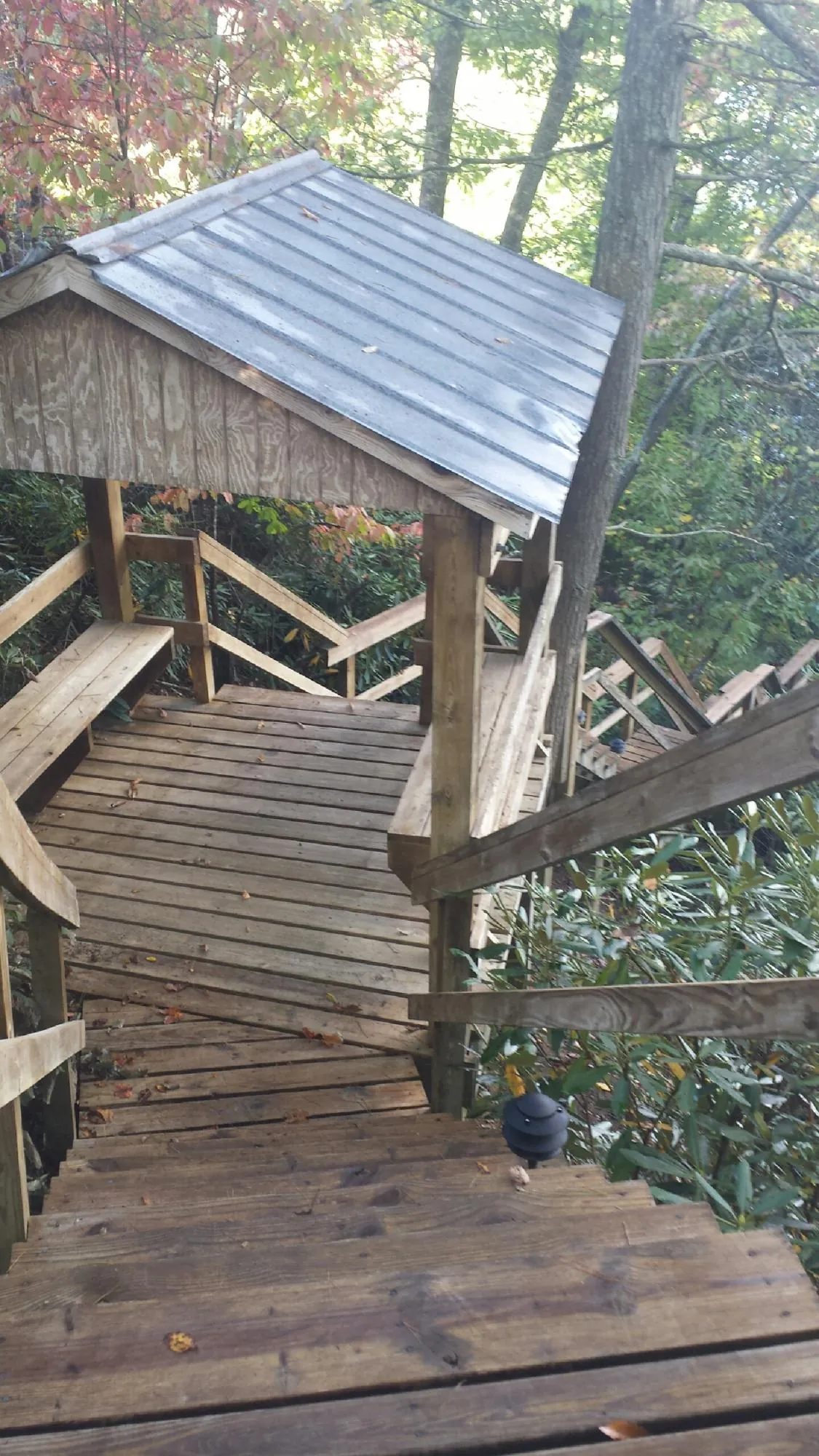 Metal roofed shelter over wooden steps on a wooded walkway — Skylight Repair & Installation work by our crew in Blauvelt